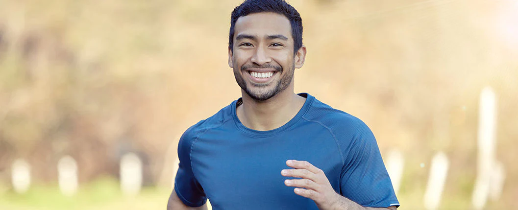 homem com camiseta azul sorrindo e correndo 