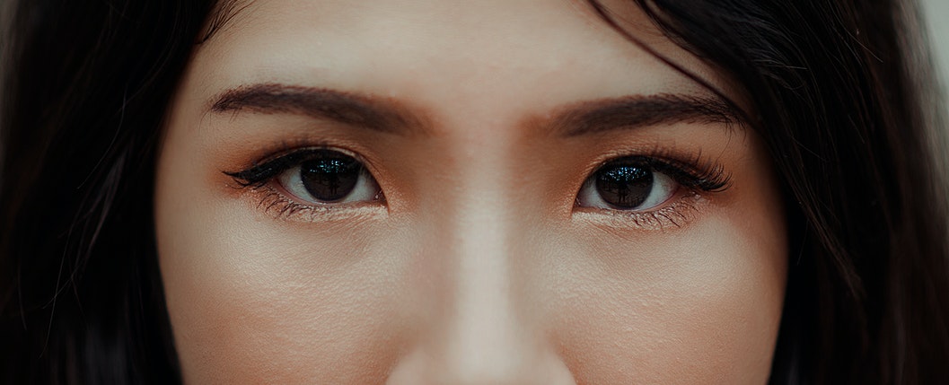 foto de perto do rosto de uma mulher, mostrando apenas os olhos puxados com maquiagem simples, as sobrancelhas e um pouco do nariz